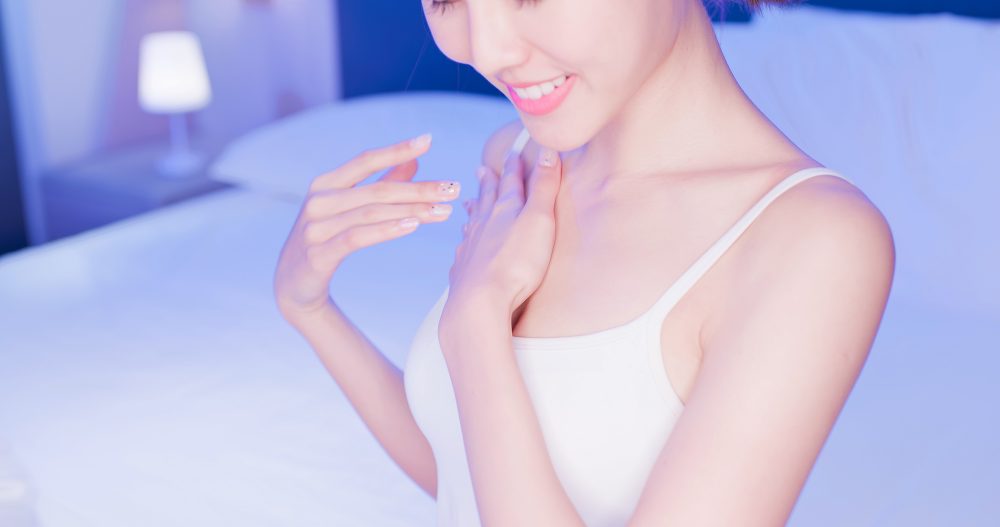 デコルテをさわる女性