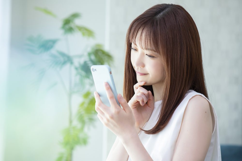 スマートフォンで調べ物をする女性