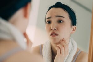 肌を心配して鏡をのぞく女性