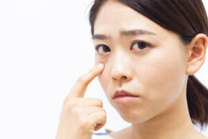 目元を指差す女性